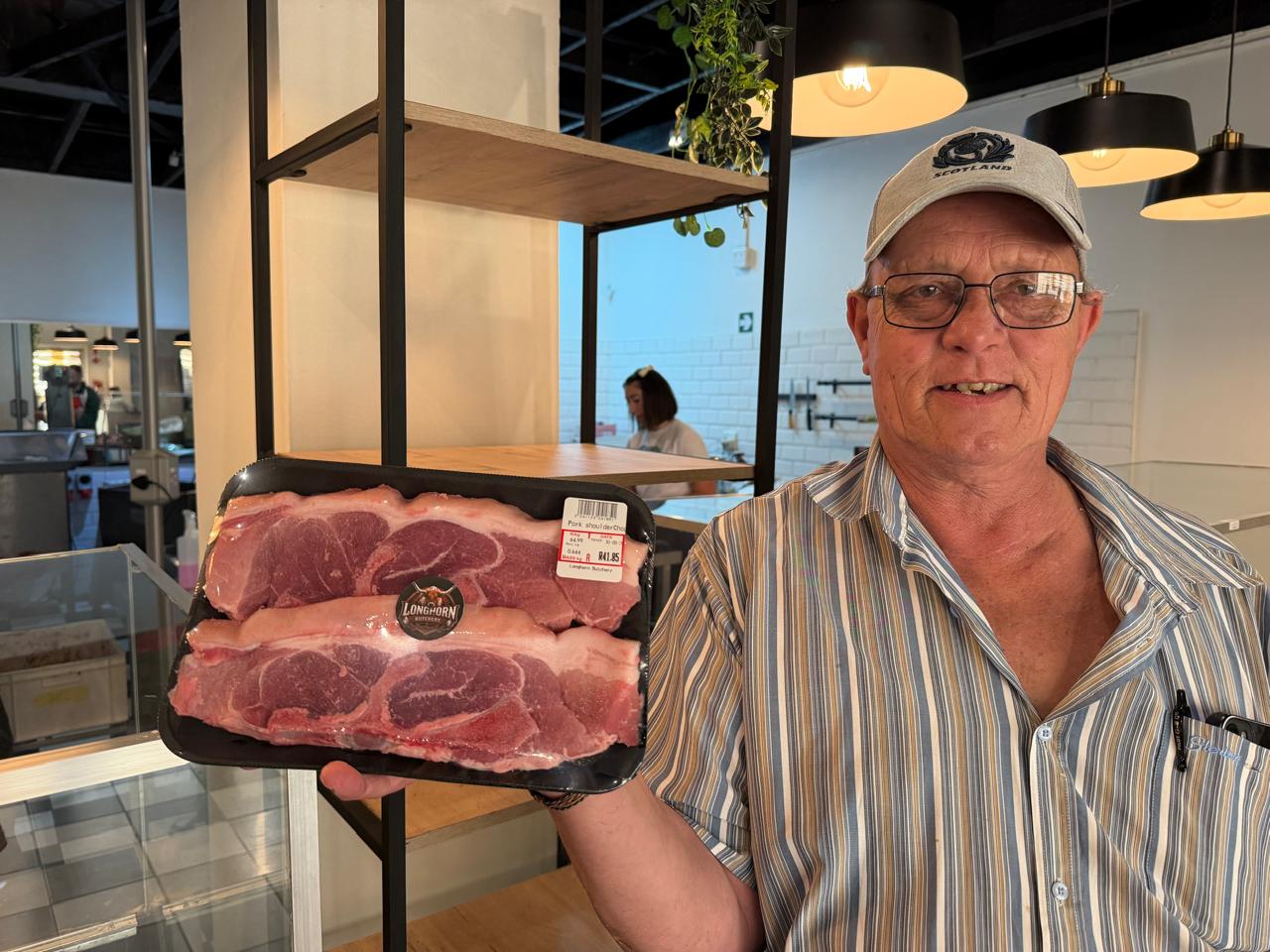 Jan, your butcher, holding a tray of pork shoulder chops at Longhorn Butchery